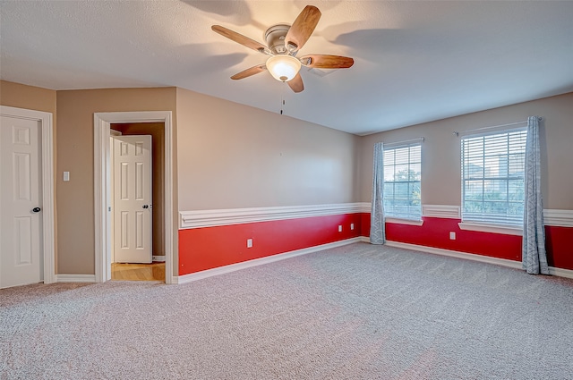 unfurnished room with ceiling fan, carpet floors, and a textured ceiling