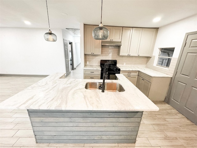 kitchen with black range with gas cooktop, decorative light fixtures, sink, and decorative backsplash