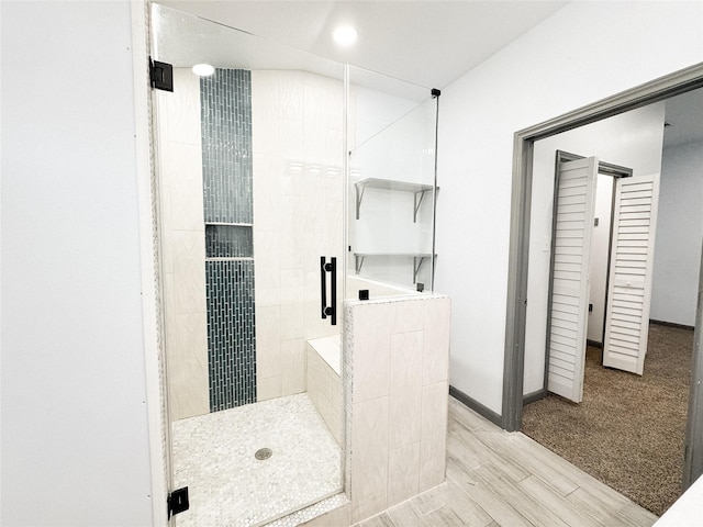 bathroom featuring an enclosed shower and wood-type flooring