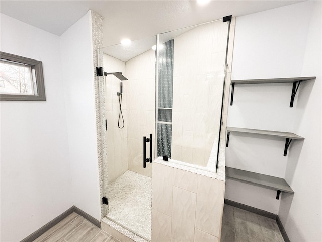 bathroom featuring a shower with shower door and hardwood / wood-style flooring