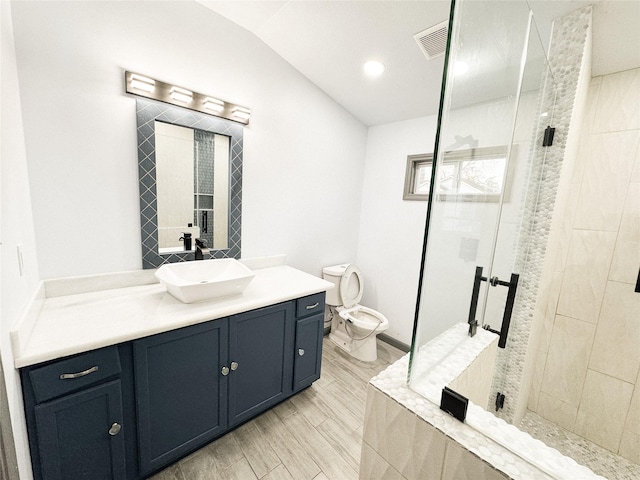 bathroom featuring toilet, an enclosed shower, vaulted ceiling, and vanity