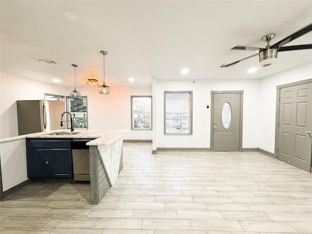 kitchen featuring kitchen peninsula, hanging light fixtures, appliances with stainless steel finishes, ceiling fan, and sink