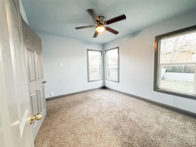 carpeted spare room featuring ceiling fan