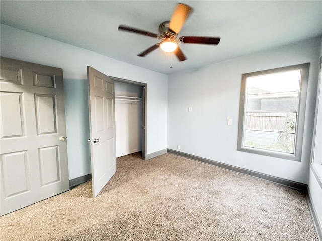 unfurnished bedroom featuring ceiling fan, light colored carpet, and a closet