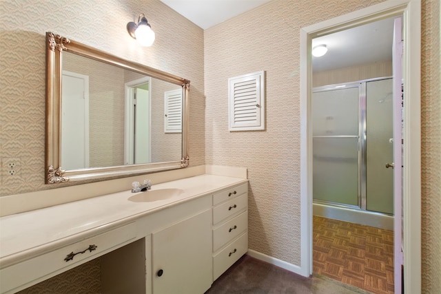 bathroom with vanity, parquet floors, and a shower with shower door