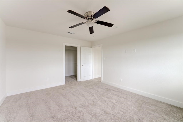 unfurnished bedroom featuring a closet, light colored carpet, visible vents, a ceiling fan, and baseboards