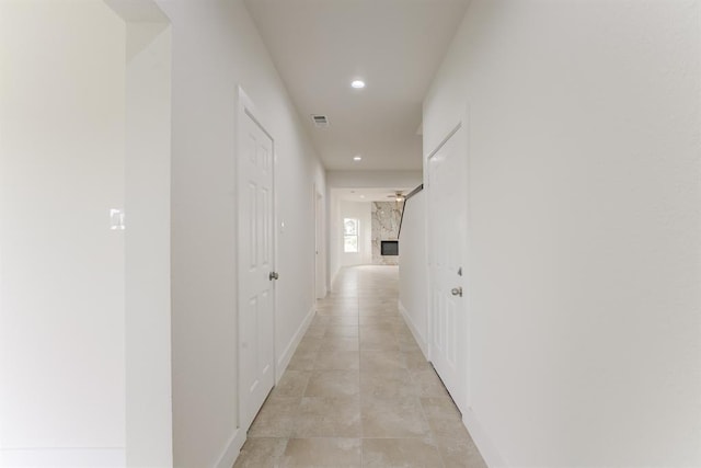 hallway featuring baseboards, visible vents, and recessed lighting