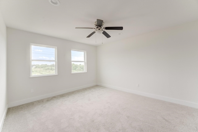 carpeted empty room with ceiling fan and baseboards