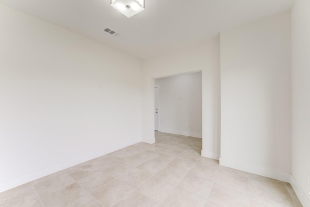 unfurnished room with light tile patterned floors, visible vents, and baseboards