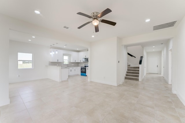 unfurnished living room featuring a ceiling fan, recessed lighting, visible vents, and stairway