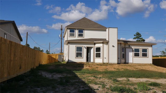 view of front of home with a shingled roof and a fenced backyard