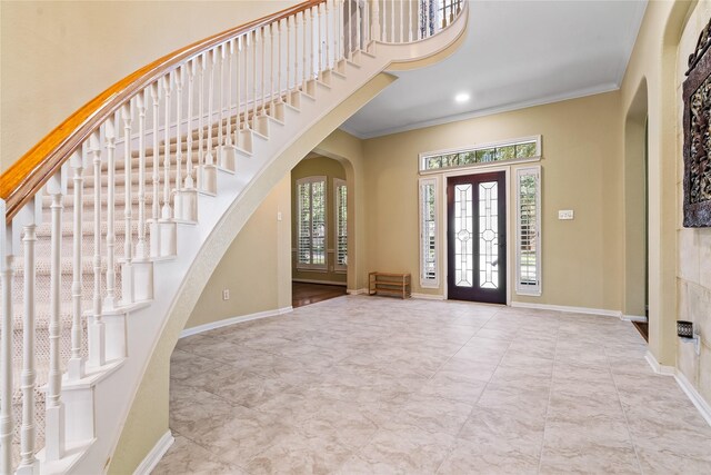 foyer with crown molding and french doors