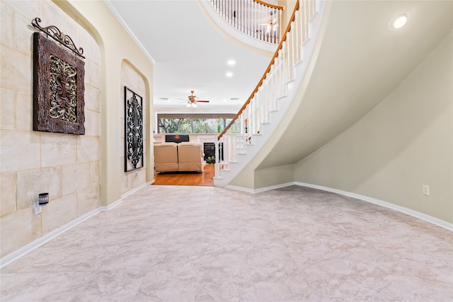 foyer entrance with ceiling fan and ornamental molding