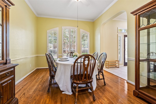 dining area featuring ceiling fan, wood-type flooring, and ornamental molding