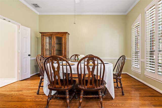 dining space featuring crown molding and light wood-type flooring