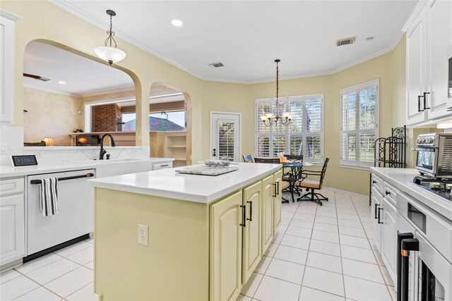 kitchen featuring dishwasher, ornamental molding, decorative light fixtures, a kitchen island, and a chandelier