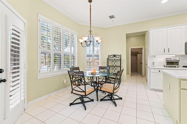 dining room featuring crown molding, light tile patterned floors, and a chandelier