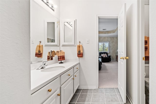 bathroom featuring tile patterned flooring, baseboards, vanity, and toilet