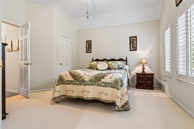 bedroom with carpet floors, ornamental molding, and vaulted ceiling