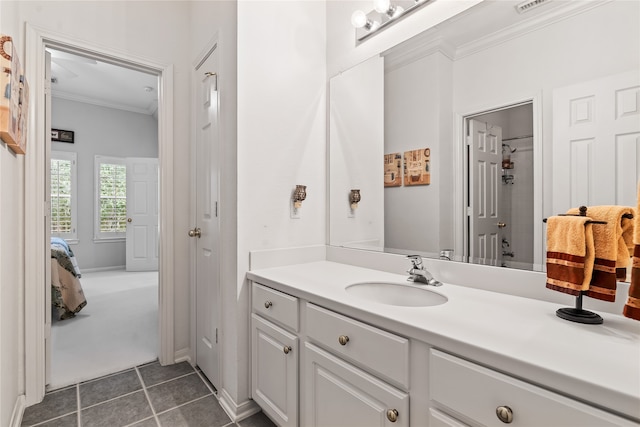 bathroom featuring tile patterned flooring, vanity, crown molding, and tiled shower / bath