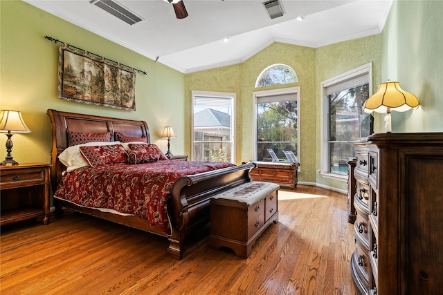 bedroom with multiple windows, ceiling fan, wood-type flooring, and vaulted ceiling