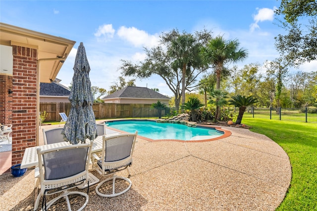 view of swimming pool with a yard and a patio