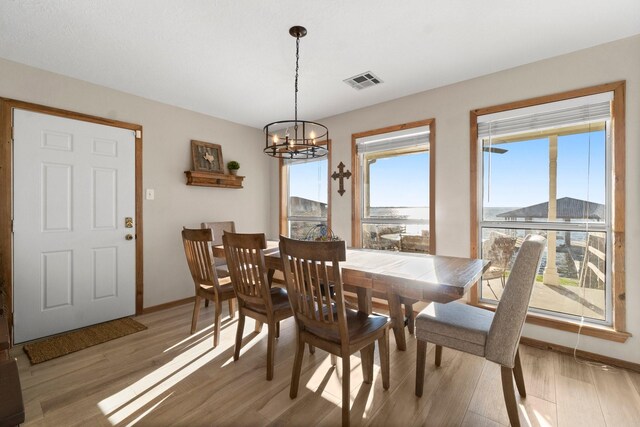 dining room with hardwood / wood-style floors and an inviting chandelier