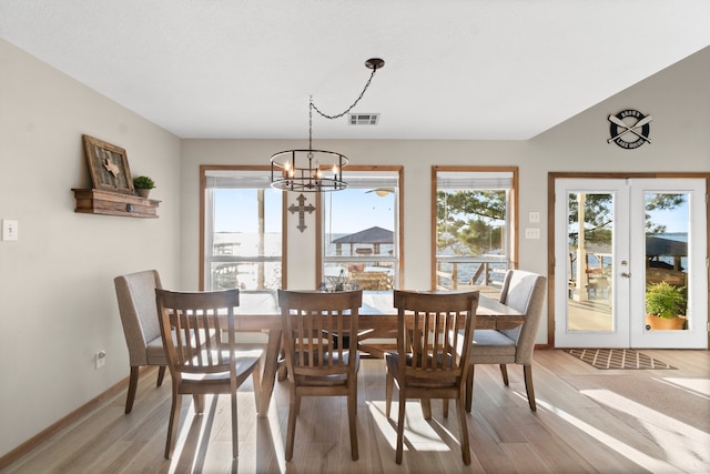 dining area with an inviting chandelier, light hardwood / wood-style flooring, and a wealth of natural light