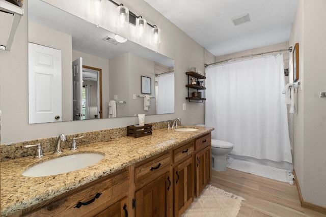 172 Little Dove, Livingston, TX 77351 - bathroom featuring wood finished floors, double vanity, toilet, and baseboards