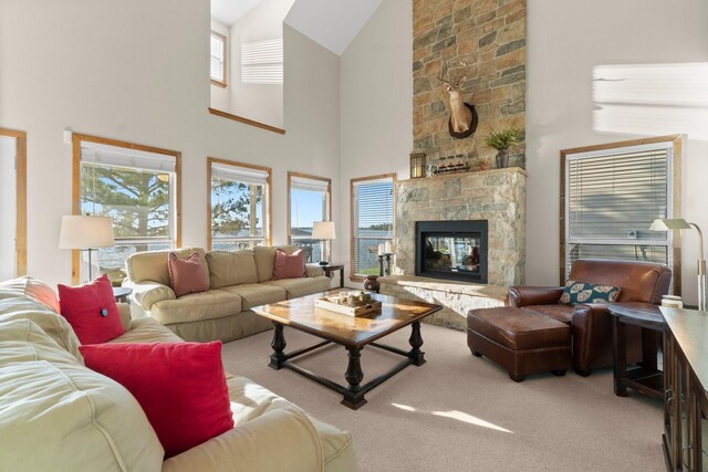 carpeted living room with a fireplace and high vaulted ceiling