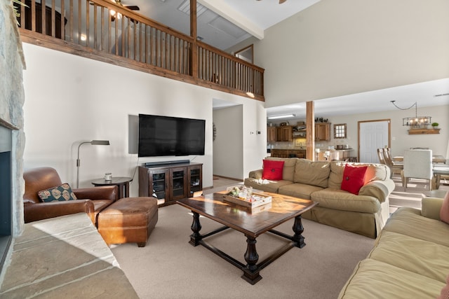 carpeted living room featuring a high ceiling and ceiling fan with notable chandelier