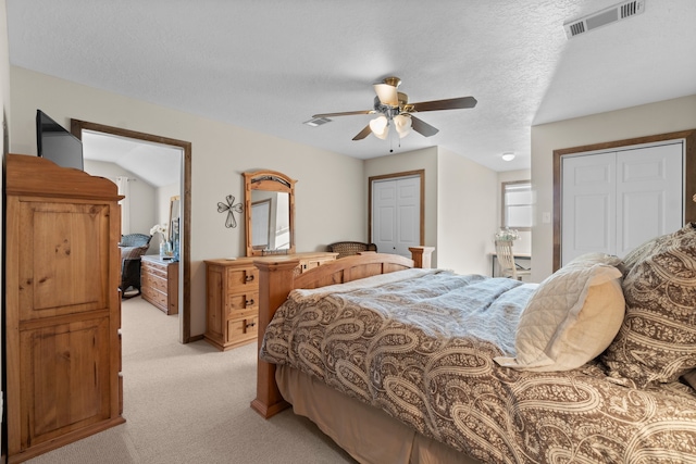 carpeted bedroom with ceiling fan and a textured ceiling