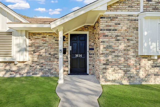 property entrance with a lawn