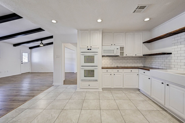 kitchen featuring white cabinetry, ceiling fan, vaulted ceiling with beams, light hardwood / wood-style floors, and white appliances