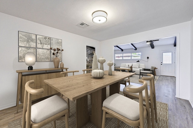 dining area with hardwood / wood-style flooring and beamed ceiling