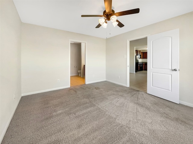 spare room featuring ceiling fan and light colored carpet