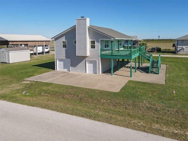 back of property featuring a lawn, a patio area, a garage, and a deck