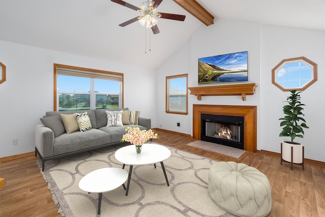 living room with vaulted ceiling with beams, ceiling fan, and light hardwood / wood-style flooring