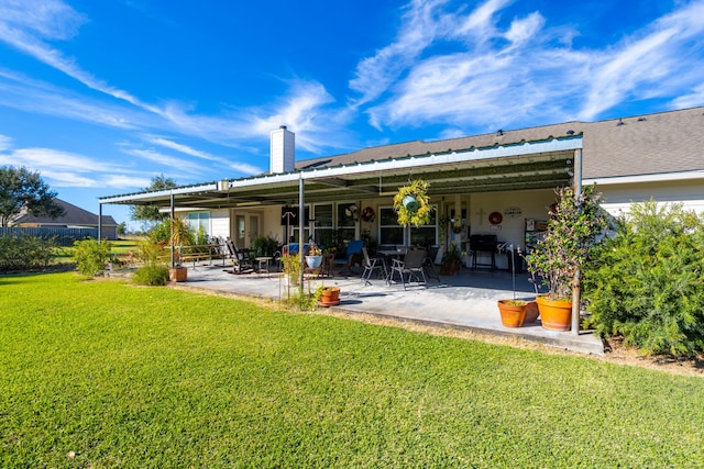 rear view of house featuring a patio area and a yard