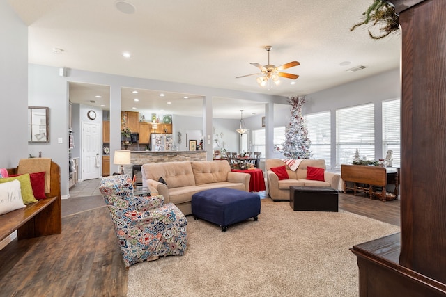 living room with ceiling fan, wood-type flooring, and a textured ceiling