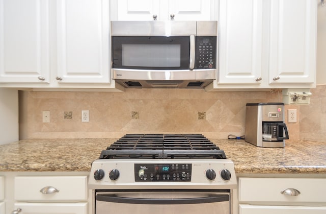 kitchen with decorative backsplash, light stone counters, white cabinetry, and appliances with stainless steel finishes