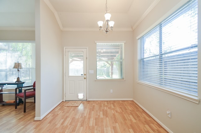 foyer featuring light hardwood / wood-style flooring, ornamental molding, and an inviting chandelier