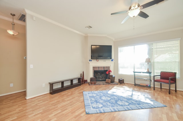 living room featuring a fireplace, wood-type flooring, ceiling fan, and crown molding