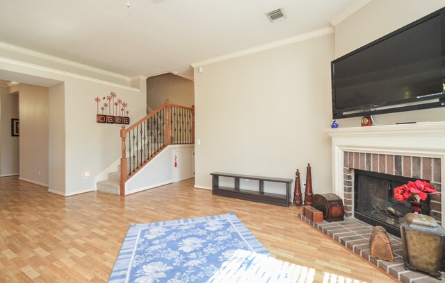 living room featuring crown molding, a fireplace, and hardwood / wood-style flooring