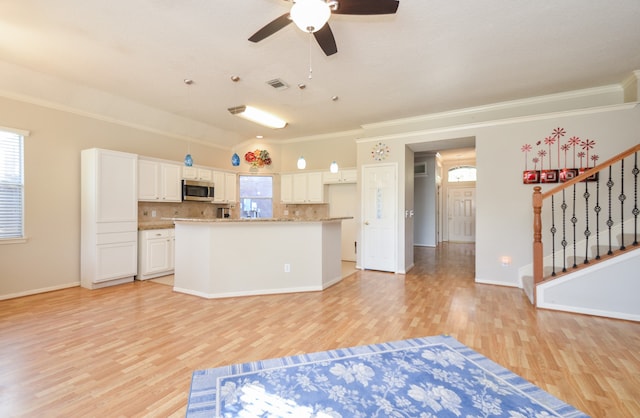 kitchen with decorative backsplash, ornamental molding, ceiling fan, light hardwood / wood-style flooring, and white cabinetry