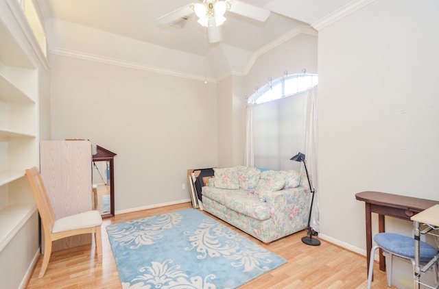 living area featuring hardwood / wood-style flooring, ceiling fan, and crown molding