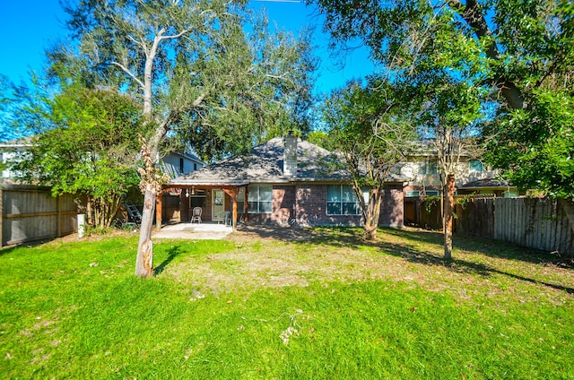 back of house featuring a lawn and a patio area