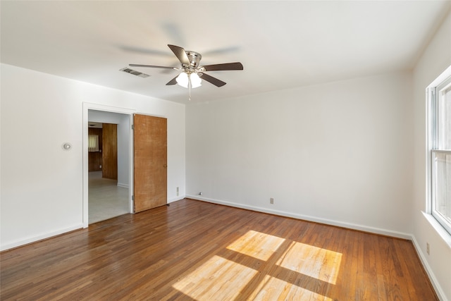 spare room with ceiling fan, hardwood / wood-style flooring, and a wealth of natural light