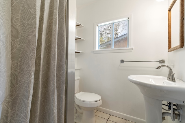 bathroom with toilet and tile patterned flooring