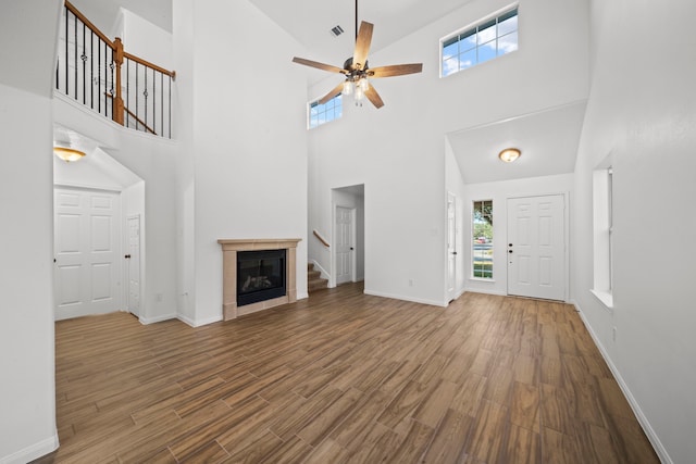 unfurnished living room featuring hardwood / wood-style floors, a healthy amount of sunlight, and high vaulted ceiling